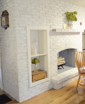 an oversized whitewashed brick non-working fireplace with built-in shelves and potted greenery is a stylish and cozy decoration