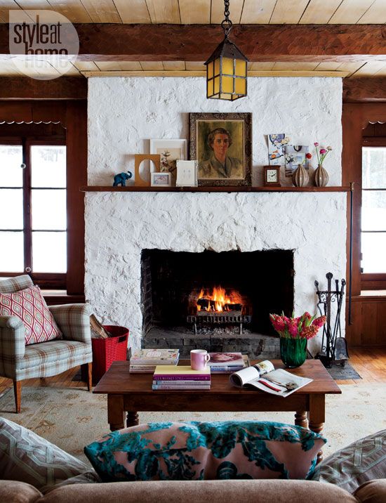 a whitewashed stone and plaster fireplace with a dark stained mantel with vintage decor is a chic and stylish decoration