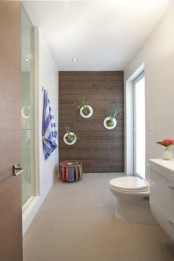 a contemporary bathroom with wall planters with greenery that enliven this space at once and make it fresher