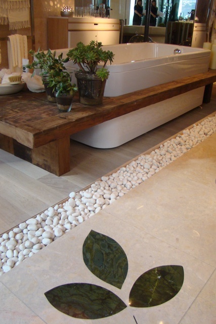some sheer planters with succulents put on the bench over the tub and pebbles give a real spa feel to the space
