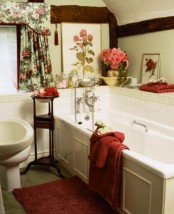 a vintage bathroom with floral artworks, curtains and some blooms in a vase and in a bowl for a sweet feel