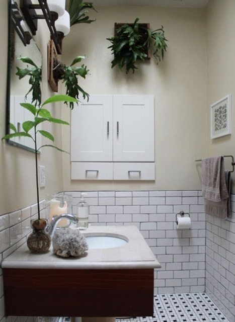 a neutral bathroom with wall planters and a plant on the sink to refresh this space and make it lively and cool