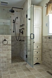 a neutral vintage bathroom clad with tiles all over, with a pony wall in the shower space