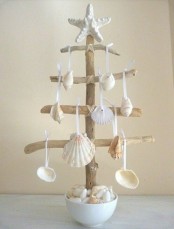 a wooden Christmas tree with seashells and starfish as decor is a very creative decor idea for a beach Christmas house