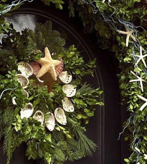 a beach Christmas wreath of greenery, evergreens, seashells and a starfish on top is a lovely idea for a beach home