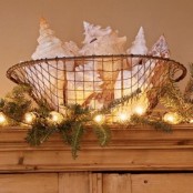 a wire basket with oversized seashells, lights and evergreens around is a gorgeous beach Christmas decoration or centerpiece