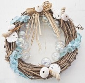 a beach Christmas wreath of vine with clear glass baubles, seashells, sea urchins and light blue sea glass is amazing
