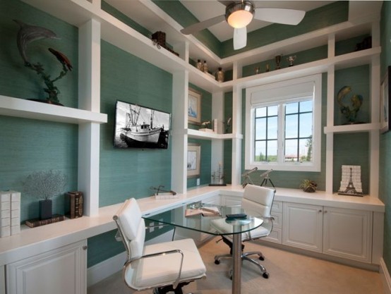 an aqua-inspired home office with blue walls, open shelves and desks plus a comfy chair and a window to the beach is very cool