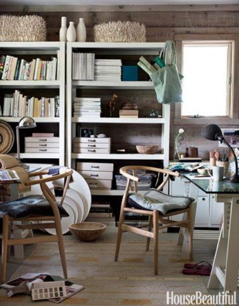 a relaxed beach home office clad with wood, with large storage units, a desk and comfortable modern chairs plus sea decor