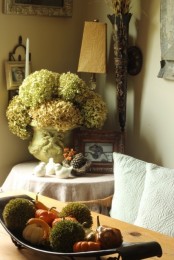 an arrangement of faux pumpkins and gourds and moss balls plus a white hydrangeas arrangement for cute rustic fall decor