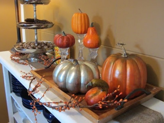 a simple fall centerpiece of a wooden tray and faux pumpkins and berries, silver stands with faux pumpkins
