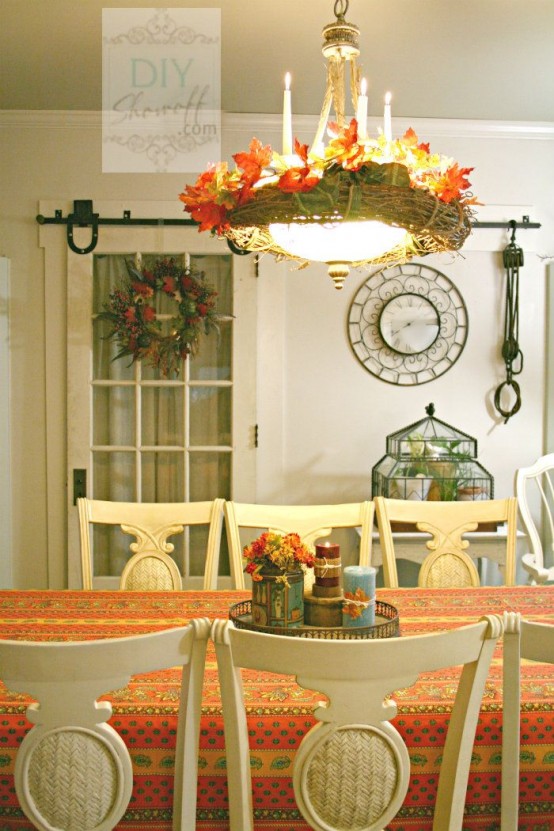 a bright printed tablecloth and a bold fall chandelier made of twine and bright fake leaves