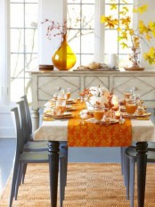 a bright dining room decorated with touches of mustard and orange and fall patterns, with bold fall leaves, berries and pumpkins