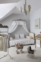 a refined neutral vintage to shabby chic bedroom with white walls and white exquisite furniture, a chic chandelier, an open closet and some vintage toys