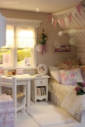 an attic shabby chic bedroom with printed wallpaper, rustic and vintage furniture in white, pastel and floral bedding and buntings over the bed
