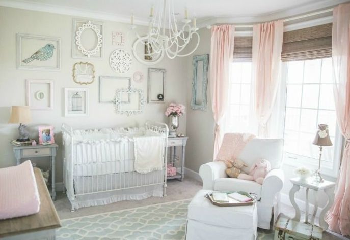 a shabby chic nursery with dove grey walls, pink textiles and pink touches, a gallery wall of empty frames and elegant furniture
