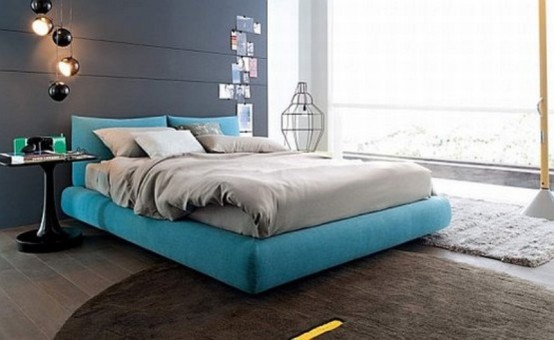 a contemporary bedroom with a graphite grey statement wall, a grey floor and rugs, a turquoise bed and grey bedding