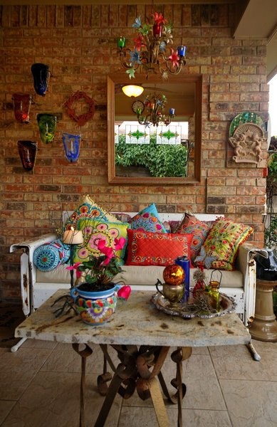 a colorful boho rug with bright masks, lanterns, pillows, planters and candle holders