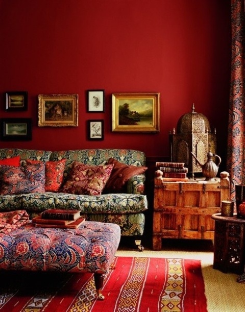 a burgundy statement wall and a matching striped rug in burgundy and gold for a strong fall feel in the space