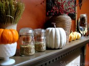 a cool fall mantel with faux pumpkins, grasses, berries and nuts in jars is a cool hint on the harvest time