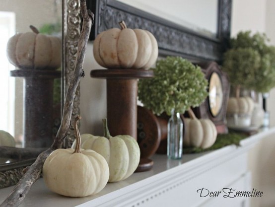 a vintage rustic mantel styled with white pumpkins, moss, green hydrangeas, metal stands