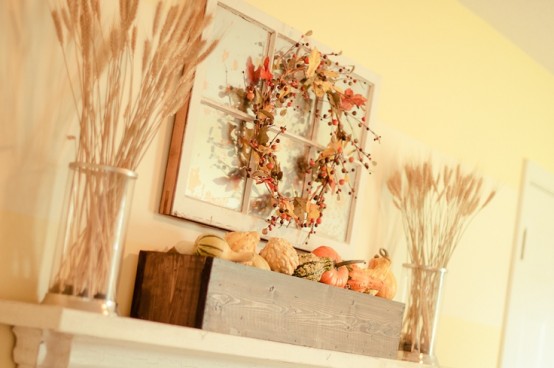 a rustic fall mantel with wheat arrangements, a faux leaf and berry wreath and a wooden box with faux pumpkins