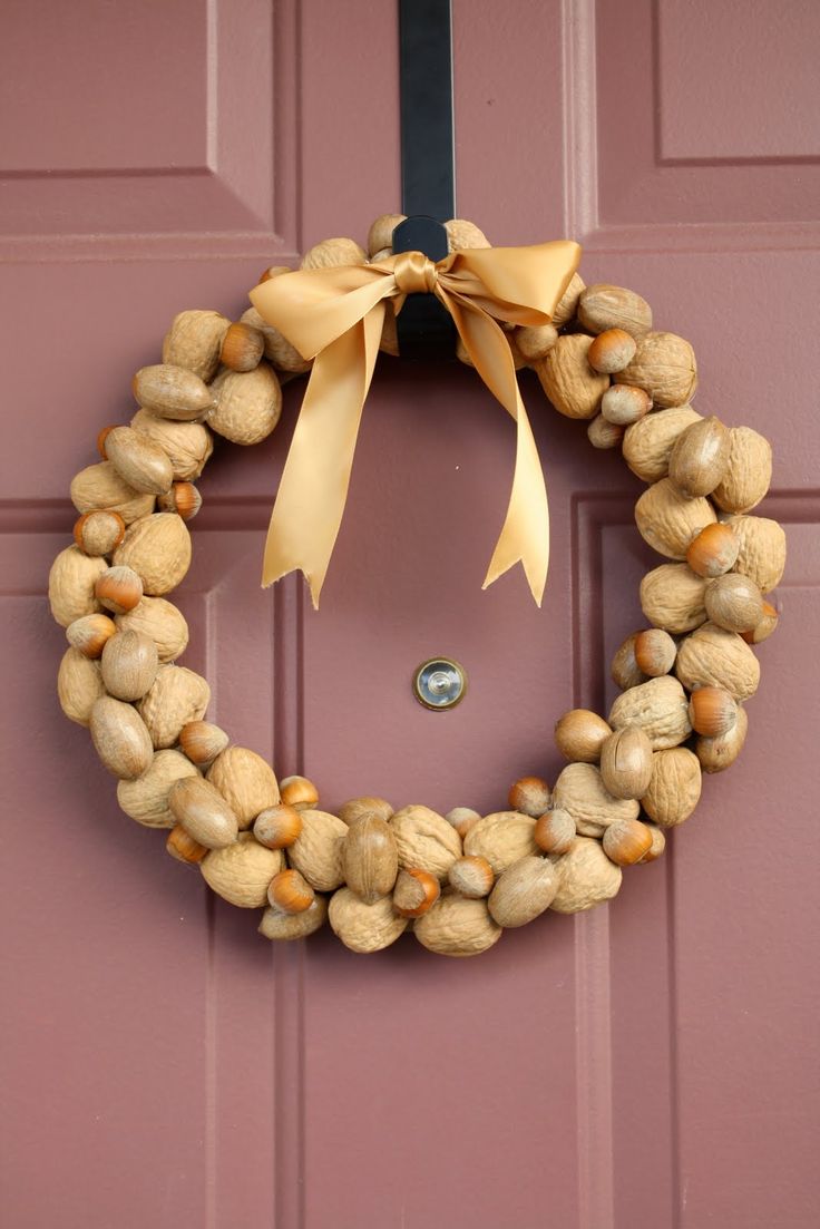 a natural and cool fall wreath made of walnuts and hazelnuts topped with a beige ribbon bow is a gorgeous idea for the fall