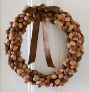 an elegant and chic fall wreath made of various kinds of nuts and topped with a brown ribbon bow is a lovely idea for vintage decor