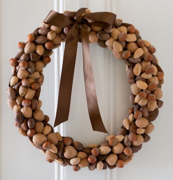 an elegant and chic fall wreath made of various kinds of nuts and topped with a brown ribbon bow is a lovely idea for vintage decor