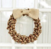 a rustic fall acorn wreath with a burlap bow is a cool and all-natural decor idea for the season, looks nice and cool