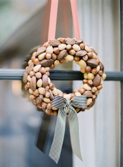a tiny and cute fall wreath fully covered with nuts of various kinds and with a ribbon bow is amazing for the fall