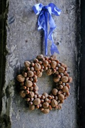 a small and chic fall wreath covered with nuts of various kinds and with a blue ribbon bow on top is a fantastic idea for rustic home decor
