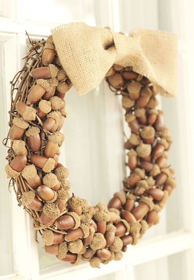 a pretty rustic fall wreath made of vine, with acorns on top and a burlap bow for an accent is a lovely idea for an organic look