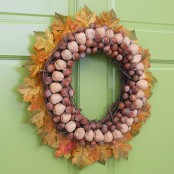 a creative and chic fall wreath made of leaves, twigs, two types of nuts is a gorgeous idea for rustic or natural fall decor