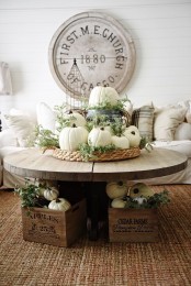 a woven tray with white pumpkins and greenery, a bucket with a pumpkin and greenery for a lush Thanksgiving centerpiece