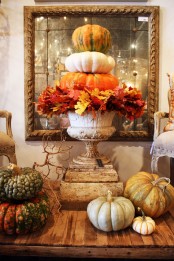 a vintage urn with lush fall leaves and a stack of natural pumpkin will give a vintage and rustic feel to the space