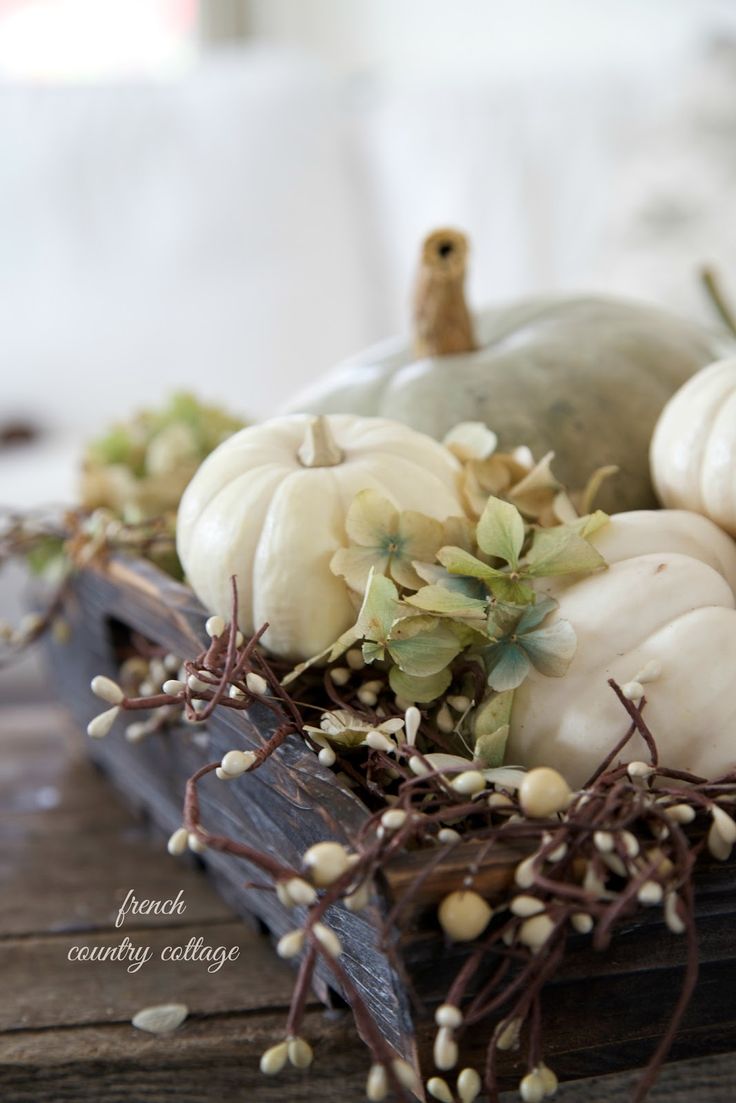 a wooden box with dried hydrangeas, pumpkins and branches with berries is a chic neutral rustic centerpiece for Thanksgiving