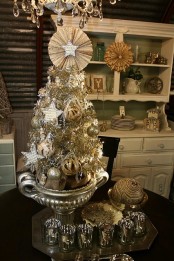 a vintage silver tabletop Christmas tree with various ornaments, paper decor and in a silver bowl
