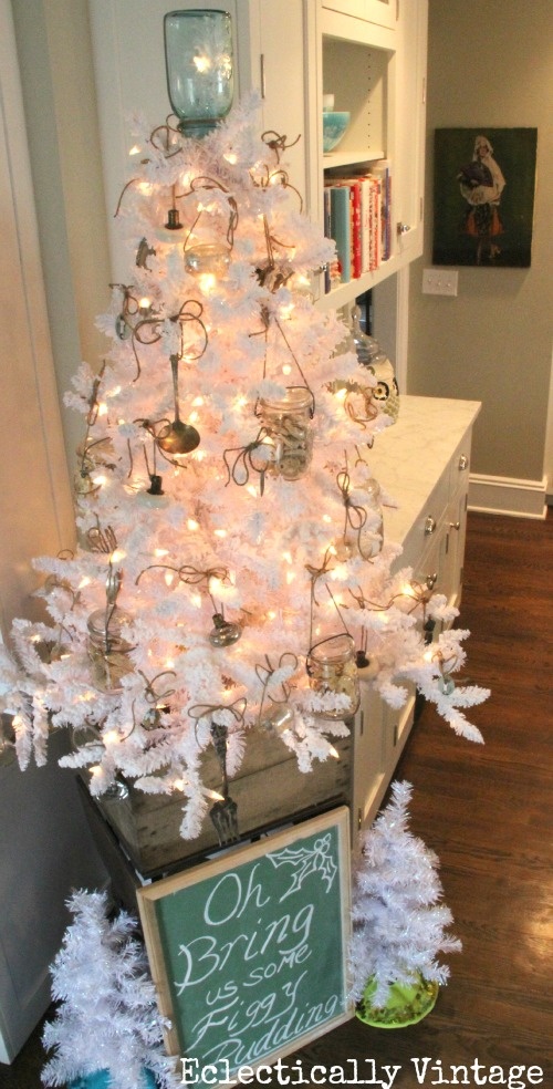 a pure white vintage Christmas tree decorated with lights and kitchen stuff  plus jars with candles for a fun touch