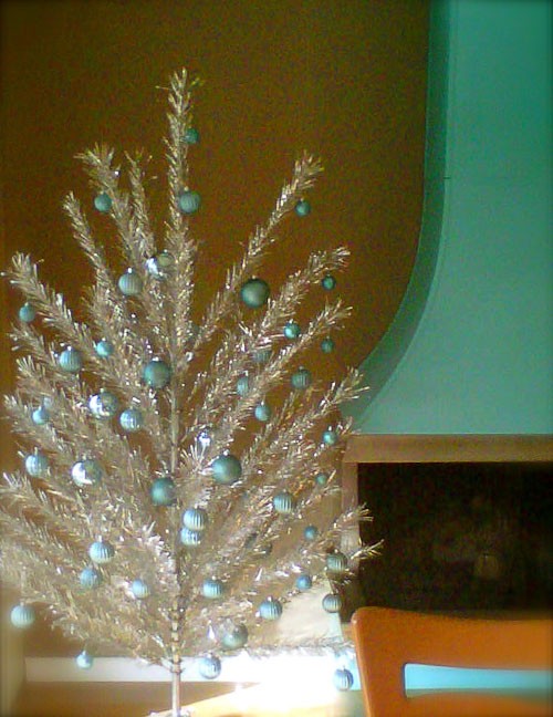 a shiny silver Christmas tree with blue ornaments feels and looks like holidays and adds a vintage feel
