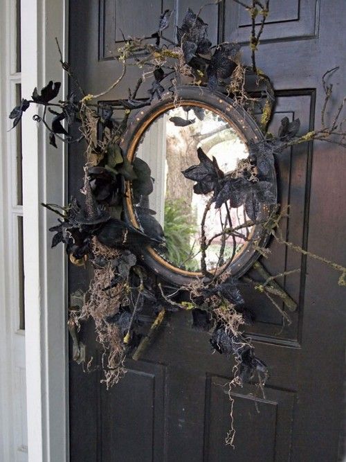 a black mirror with branches, twigs, black leaves and blackbirds is a lovely front door decoration for those who love vintage Halloween decor