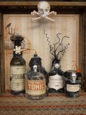 vintage Halloween decor with lovely bottles covered with spider web, skulls and twigs is a very cool and bold solution for decorating or drink styling