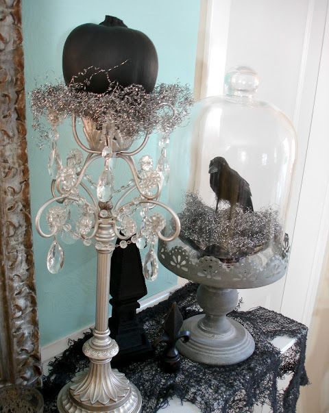 vintage Halloween decor with a tall stand and a cloche, crystals, shiny hay, a black pumpkins and a blackbird is a beautiful idea to DIY