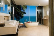 a contemporary luxurious bathroom in beige, brown and stainless steel and a glass window with the views
