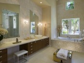 a beige and taupe bathroom with a dark-colored vanity and white surfaces and appliances