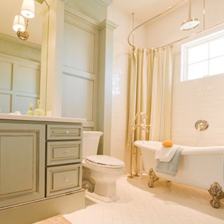 a creamy and taupe bathroom with a vintage feel, a refined vintage clawfoot bathtub and lamps