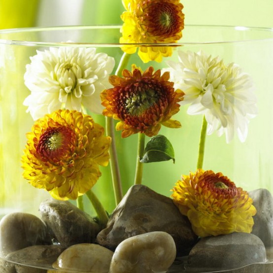 a quirky Thanksgiving centerpiece of a jar with pebbles, white and yellow blooms is a bold statement to go for