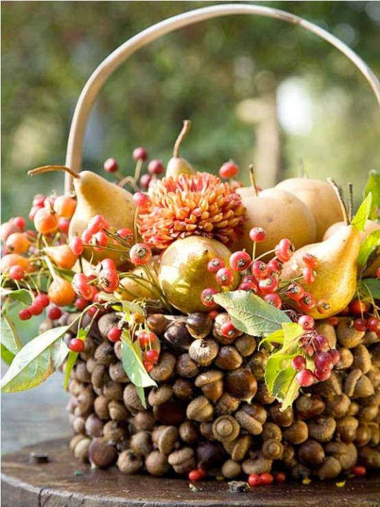 a creative and all-natural Thanksgiving centepiece of a basket covered with nuts, berries, pears and greenery is a gorgeous idea to go for