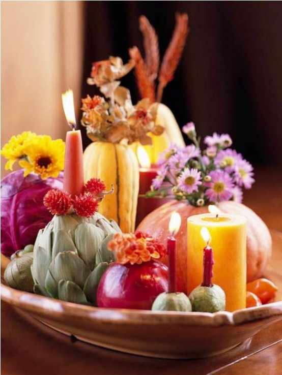 a bright and catchy Thanksgiving centerpiece of a bowl with fresh real veggies, bold blooms, dried and fresh ones, and colorful candles