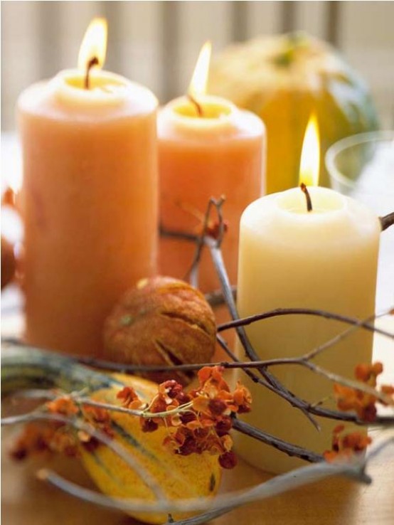 a super natural Thanksgiving centerpiece with natural-colored pillar candles, branches, dried blooms is a pretty and cool idea